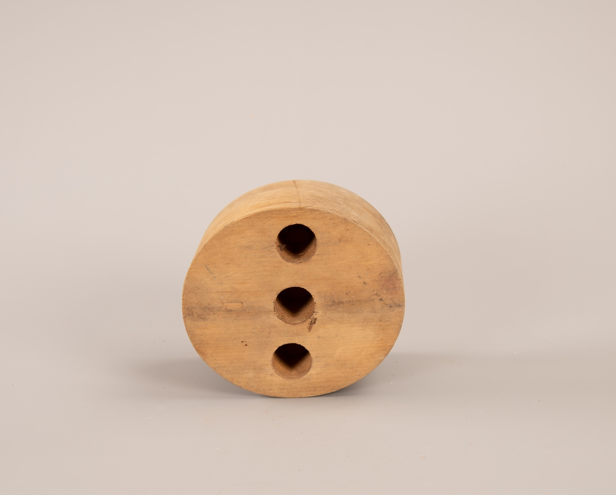 Oval hatteform med tre like store hull boret inn på oversiden. Hullene er 4,5 cm dype.