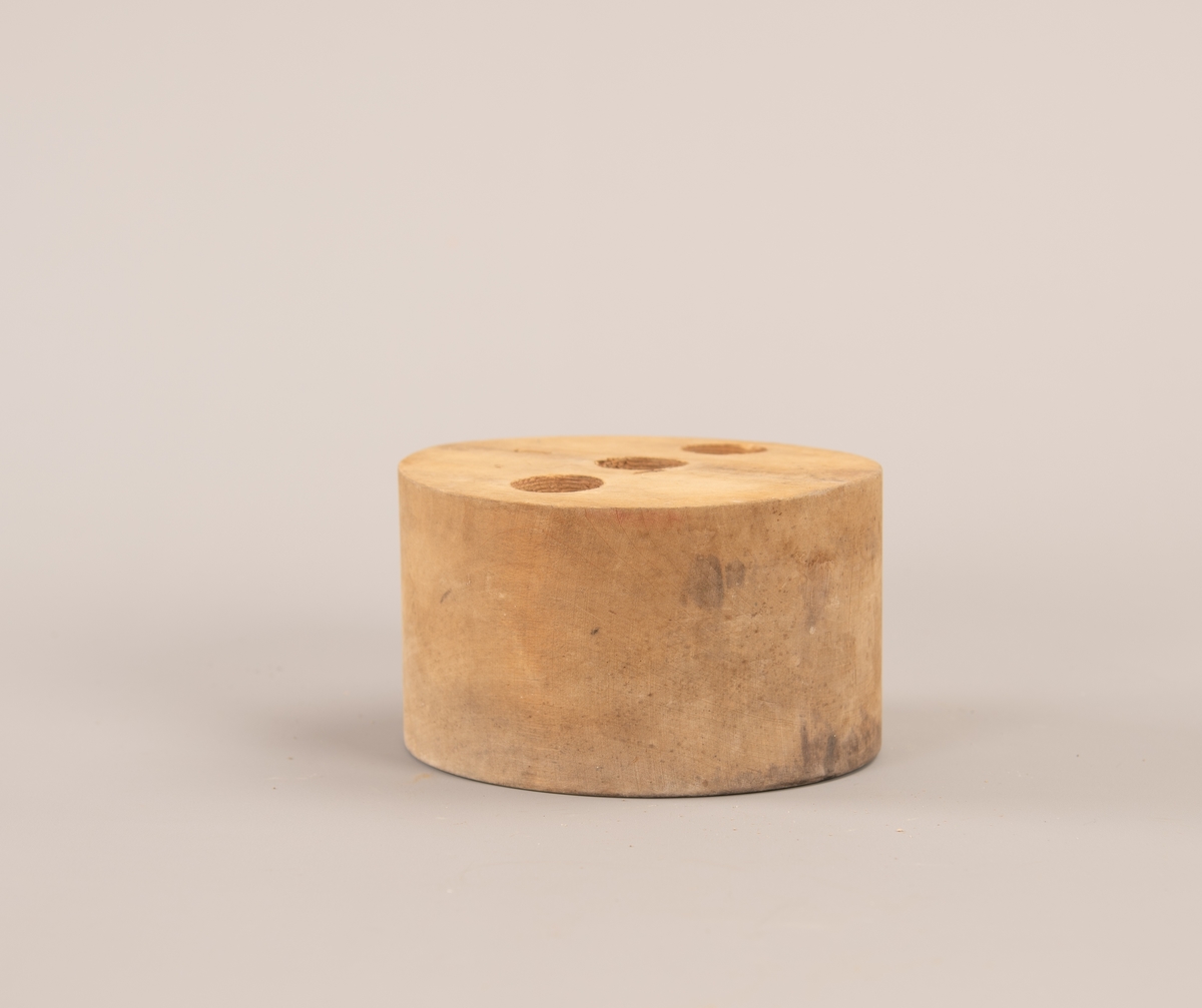 Oval hatteform med tre like store hull boret inn på oversiden. Hullene er 4,5 cm dype.