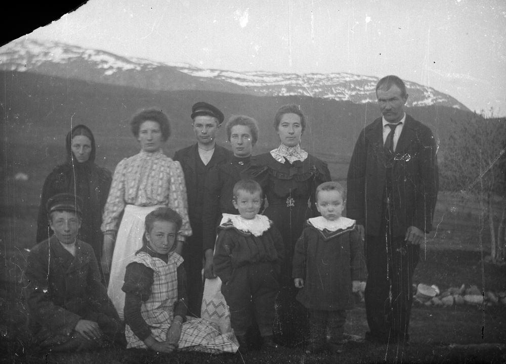 Leirfjord. En gruppe personer fotografert ute. Fjell i bakgrunnen.