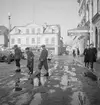 En slaskig vårdag 1948 fångar fotografen detta ögonblick på Stora torget i Linköping.