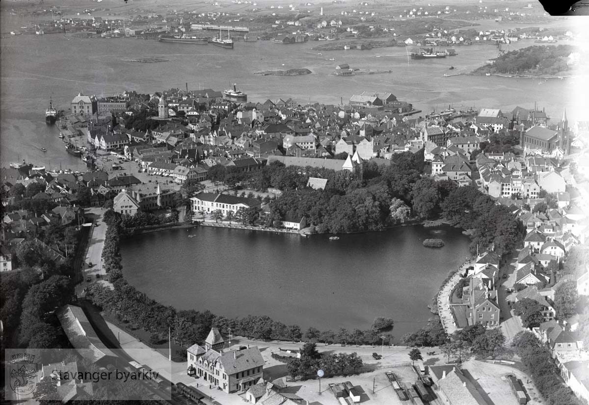 Oversiktsbilde Stavanger indre mot nord...Den gamle jernbanestasjonen, Breiavatnet, Posthuset, Kongsgård, Domkirken, Vågen, Holmen, St. Petri kirke i høyre bildekant..Gateløp: Jernbaneveien, Musegata (nå: Olav Vs gate), Kongsgata..I bakgrunnen Byfjorden, Sølyst, Engøy, Buøy, Hundvåg, Natvigs Minne, Plentingen, Klasaskjæret.