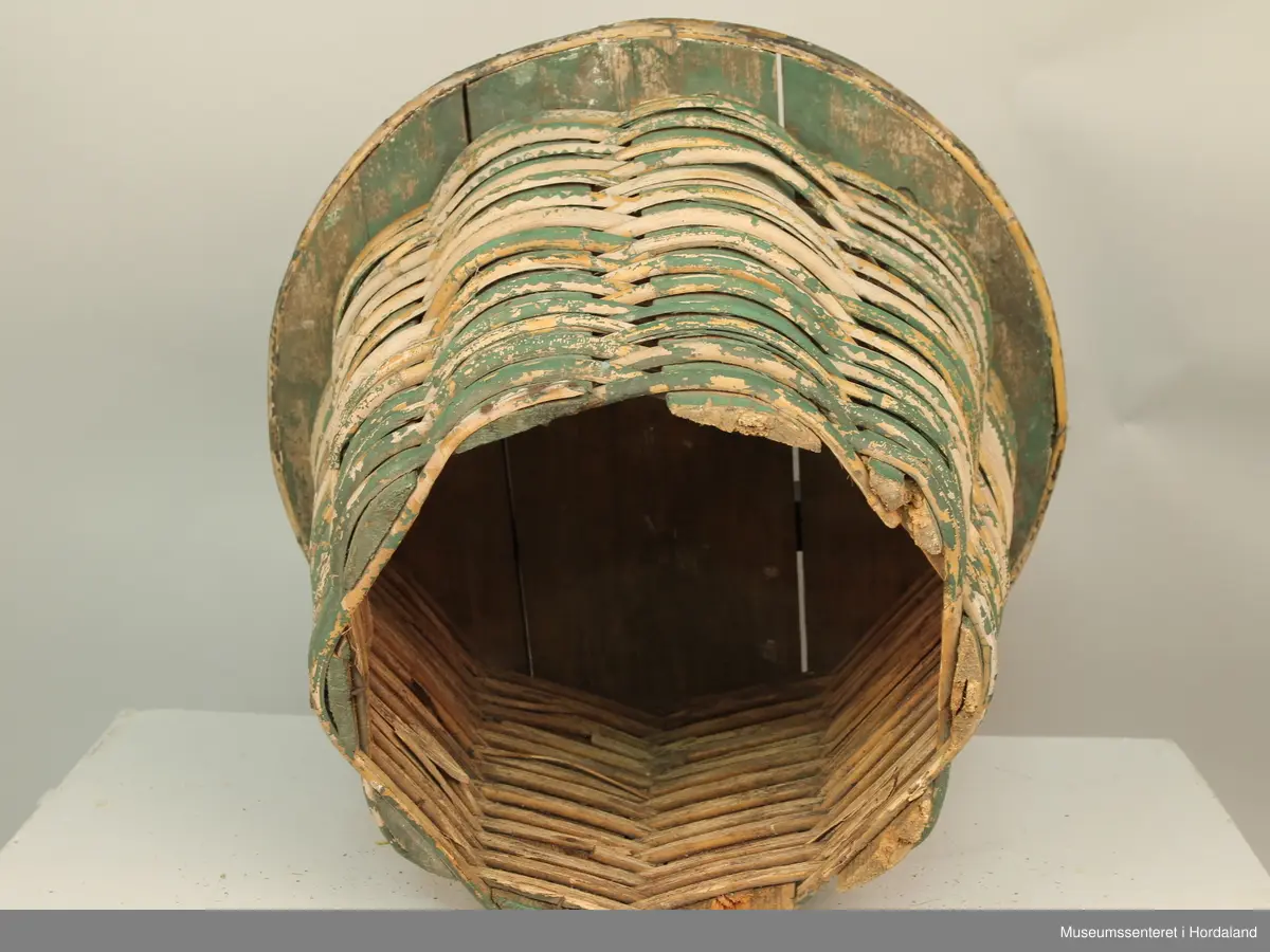 Grønn fletta korg eller kipe til å ha fisk i.