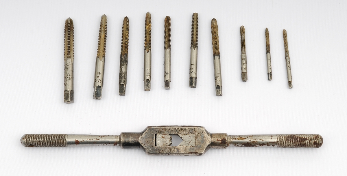 Gjengeverktøy i original trekasse fra produsenten Greenfield tap and Die Corporation, USA bestående av syv (runde) gjengebakker/-snitt, 14 gjengetapper (fire fra andre produsenter), et svingjern for gjengetapper og to svingjern for gjengebakker. Skrinet og verktøyet bærer preg av å ha blitt brukt, men er i god stand.