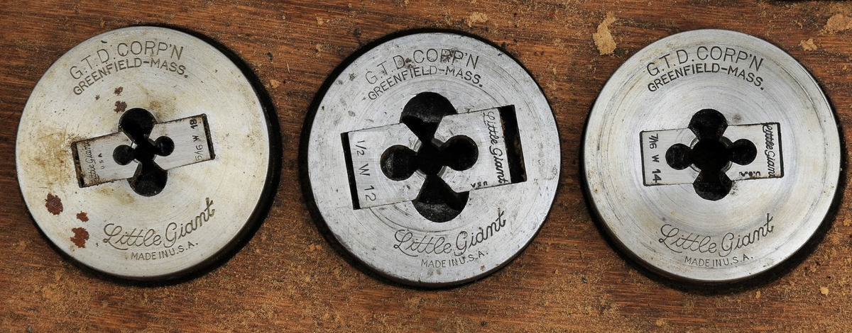 Gjengevertøy i original trekasse fra produsenten Greenfield tap and Die Corporation, USA bestående av seks (runde) gjengebakker/-snitt, 19 gjengetapper, ett svingjern for gjengetapper og ett svingjern for gjengebakker. Tappene øverst i eget brett. Skrinet og verktøyet bærer preg av å ha blitt brukt, men er i god stand.