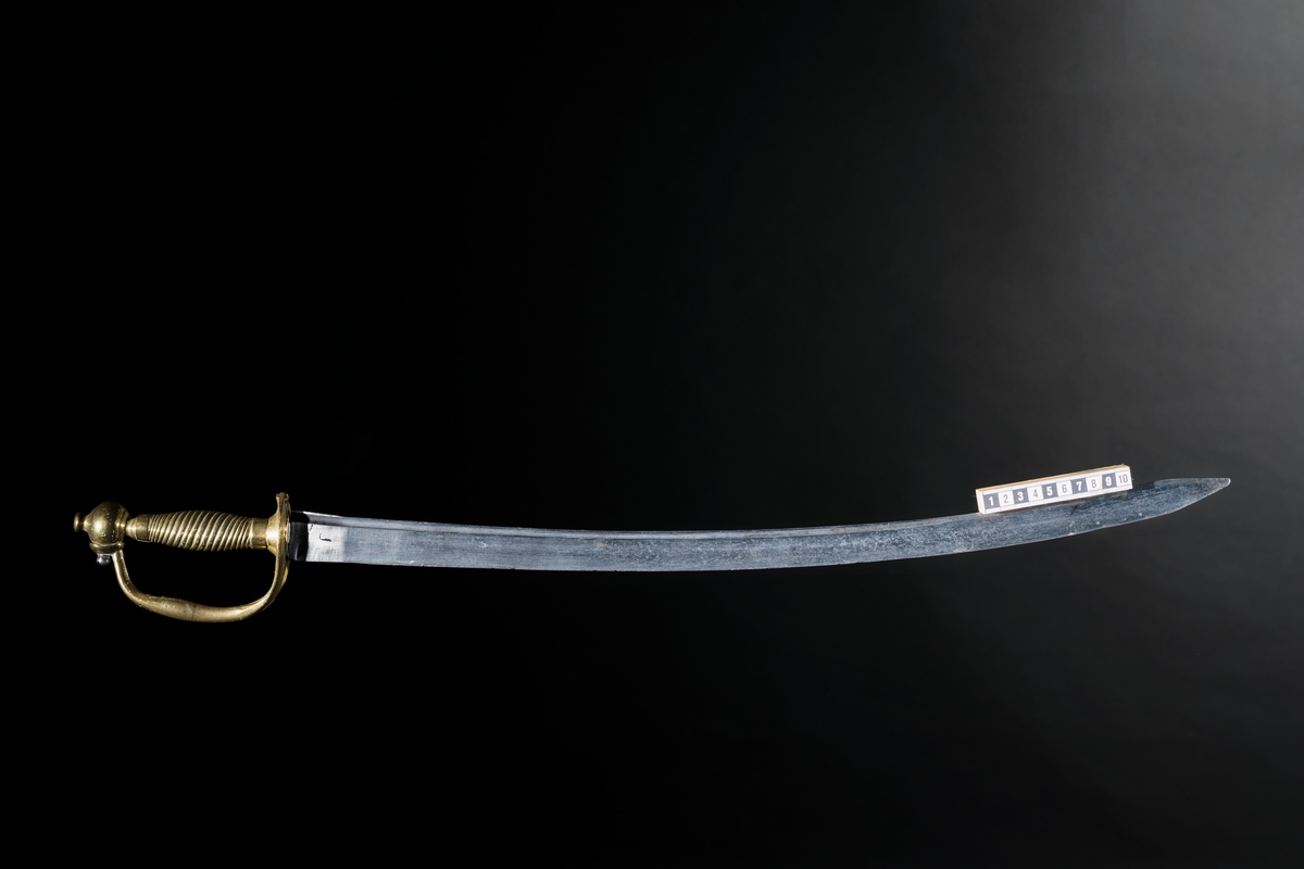 Infanterihuggare, obekant härkomst, förändringsmodell/1748-95 för Svea artilleri. Material: Klingan av stål, något böjd, fästet av mässing. Ingen stämpling eller märkning. Troligen hemförd som krigsbyte. Tillhör statens trofésamlingar.