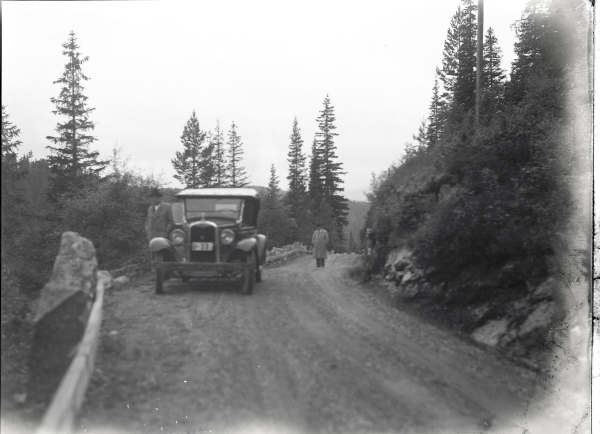 Foto av: bilen (utside og innside), veien med politi til stede, skog, åstedundersøking(?) ved et vann, utenfor en gård med politi og biler. Fra en overfallssak der to svensker visstnok var overfalt og drept, men det viste seg senere at den ene overfalt den andre. Etterforskningen ble utført av politifullmektig Hoel ved Uttrøndelag politikammer og politibetjent Dragvold ved Trondheim politikammer.