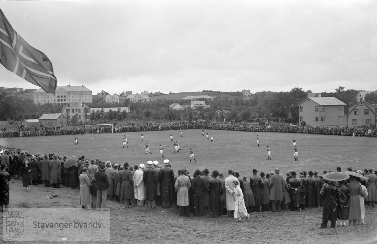 Jarlebanen med kamp og tilskuere. Sykehuset i bakgrunnen. .Fotball. .Jarlabanen i Hillevåg.