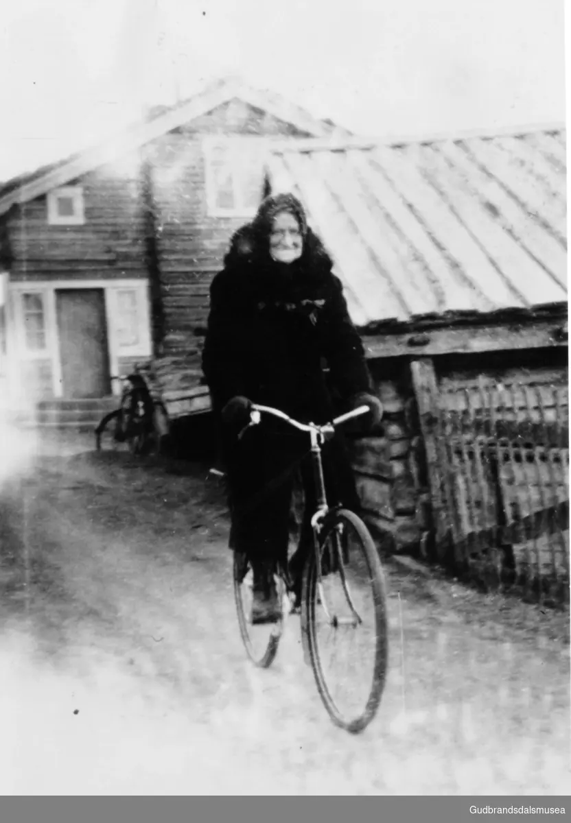 Guro Tråstad (f. 1891), organist i Skjåk kyrkje, syklar heim frå messe ca. 1933-34