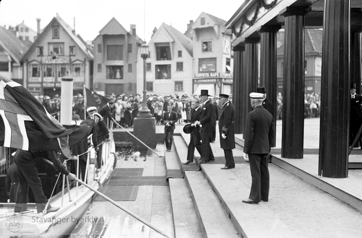 Varemessens filmer..Hans Majestet Kong Haakon VII ankommer Stavanger.Ønskes velkommen av John Norem og Johan Marnburg.Sjøhusene langs Skagen i bakgrunnen..Norges varemesse