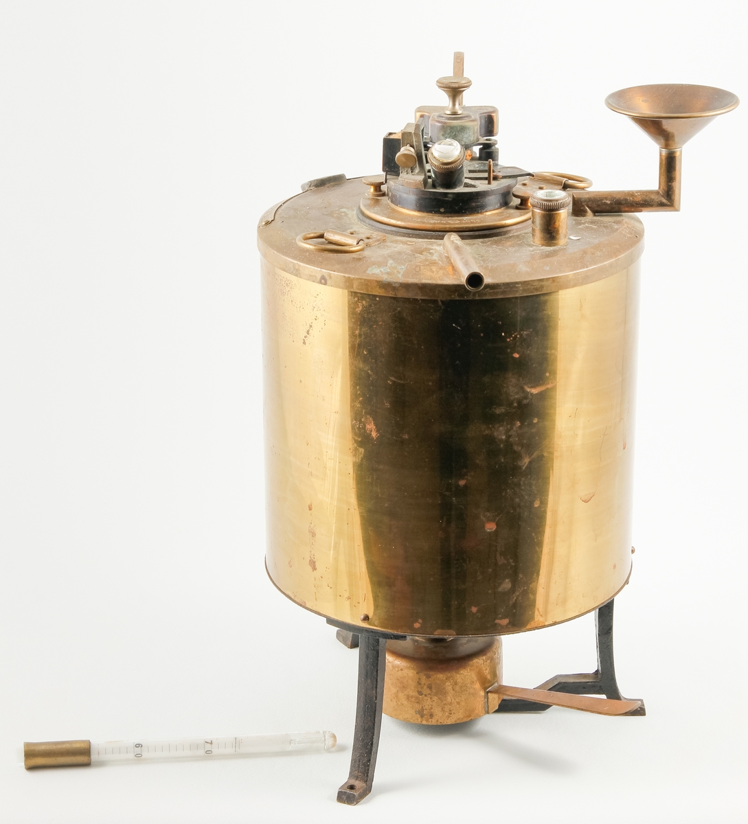 Kjemisk måleinstrument brukt til å måle såkalt flammeflukt. Instrumentet har bøtteform og består av fem ulike deler og synes å involverer en eller annen form for oppvarming. Hovedelementet står på tre føtter med skruehull slik at instrumentet kan festes til et underlag. Opprinnelig har instrumentet også hatt to thermometer (für Petroleumsproben).
