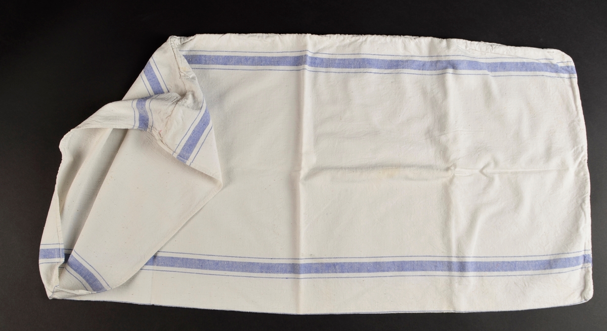 Putetrekk i kvit bomull med innvove blåe striper. Opning i eine kortenda.