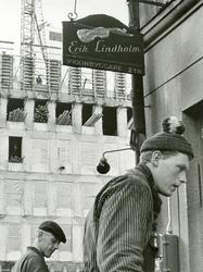 Stockholm. Två byggnadsarbetare utanför ett hus med skylten 