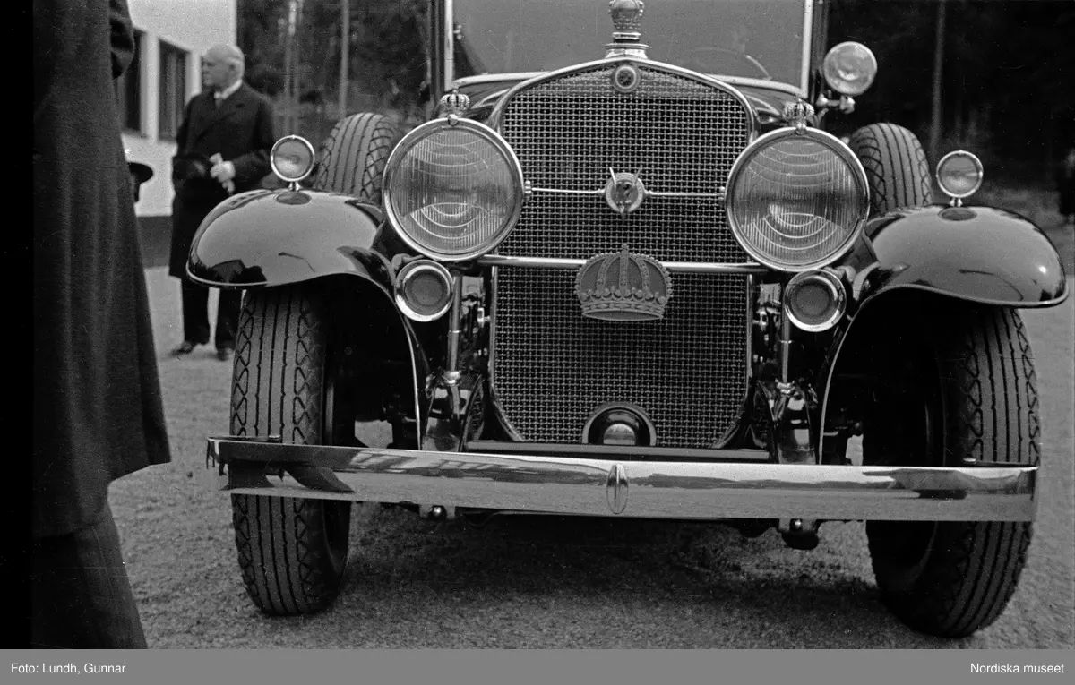 Invigning av Lovö vattenverk på Lovön i maj år 1933, chaufförer står vid parkerade bilar utanför vattenverket, närbild på en bil tillhörande Kungliga hovstallet.