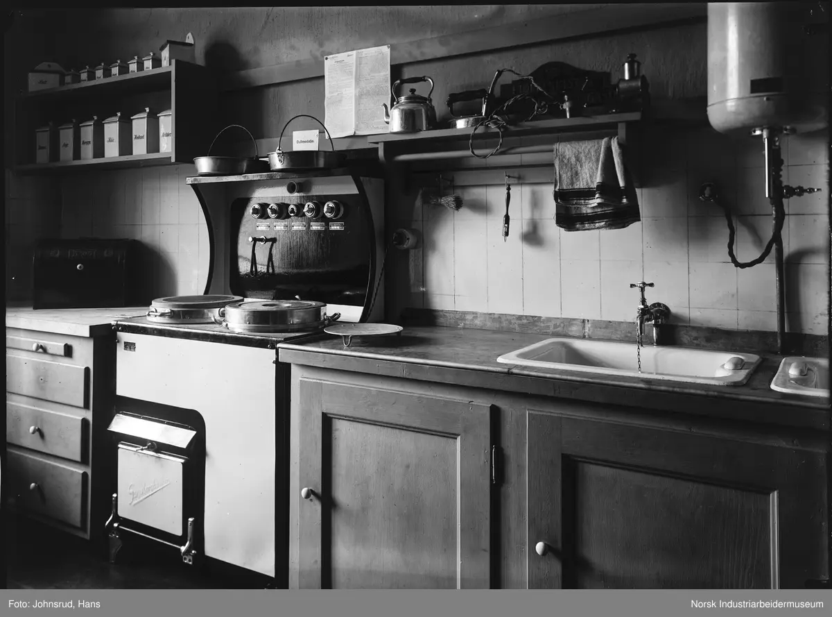 Fylkesutstillingen Kongsberg 1924. Utstilling av ett kjøkken med komfyr, vask og varmtvannsbereder.