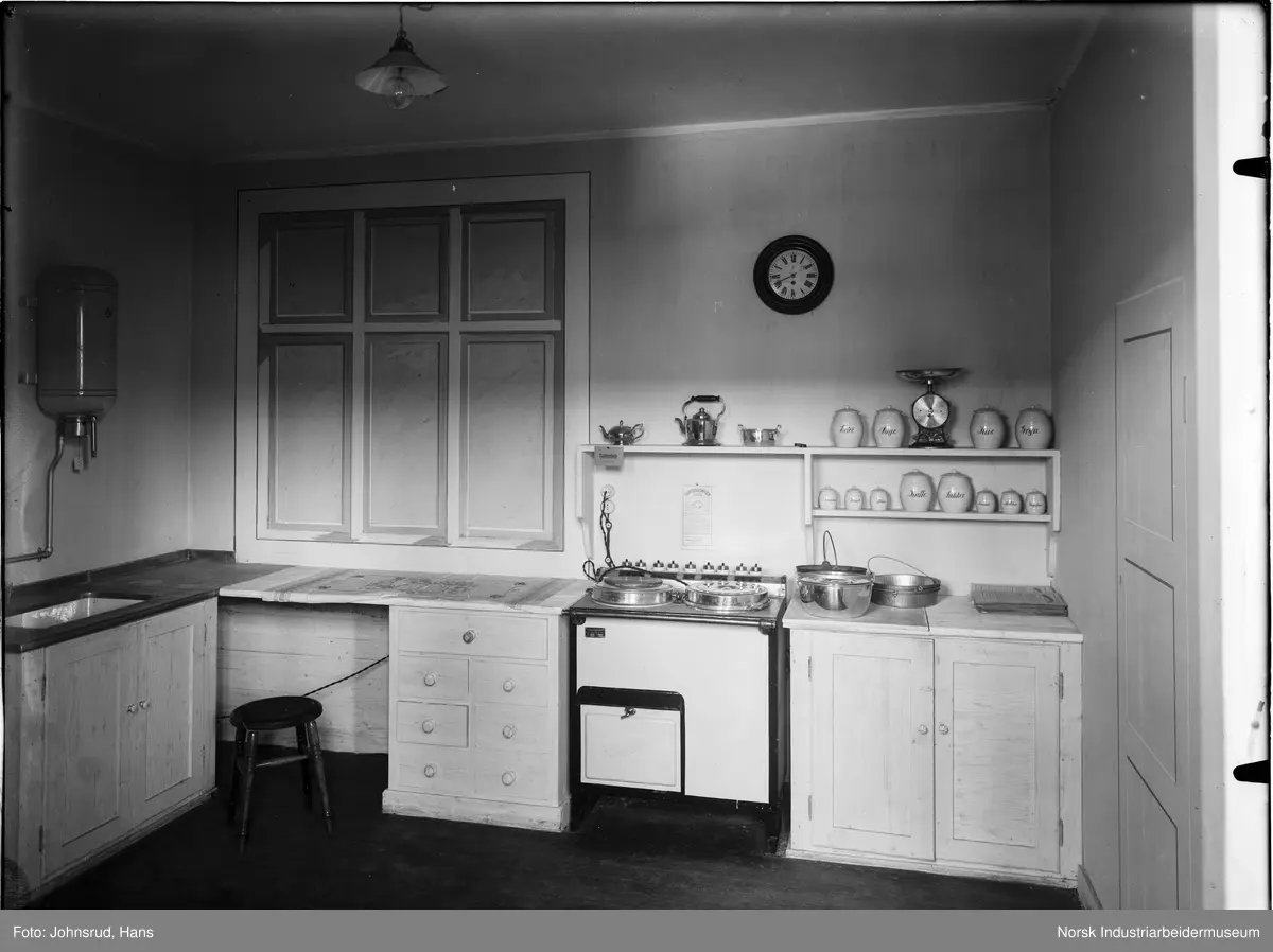 Fylkesutstillingen Kongsberg 1924. Frukt liggende på lange bord. Mann stående ved ett av bordene. Girljander hengende i taket.
