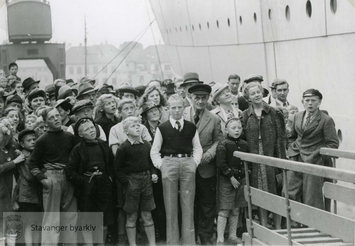 Folk står på kaien og venter på kronprinsfamilien Kronprinsfamiliens besøk i Stavanger i 1939. "Stavangerfjord" som fraktet kronprinsfamilien fra Bergen til Oslo på denne turen, ligger til kai. ..(Fra minnealbum avlevert av familien Hansen. Bildene og dokumentene er dog blitt til som ledd av L.W.Hansens kommunale virke, og er således innlemmet som del av formannskapets bildearkiv)