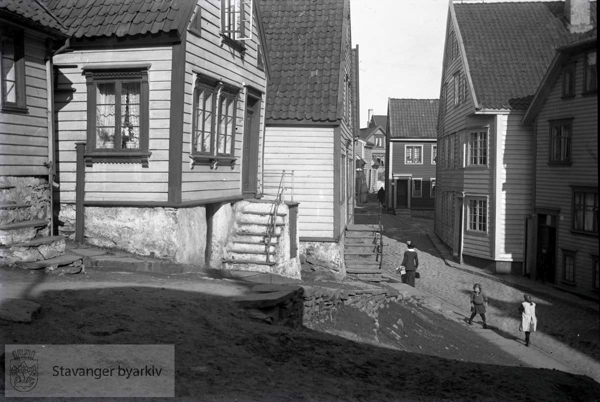 Fra venstre litt av Bergsmauet 12 (byggeår 1768, utvidet 1850), deretter Bergsmauet 14 (byggeår ca 1800), Nedre Strandgate 72 (byggeår 1861). Det mørke huset som stikker ut til høyre, er Romsøes rekeeksport ved Kundsabryggen. Helt til høyre er Nedre Strandgate 73, fiskehandler Randolf Wathne.