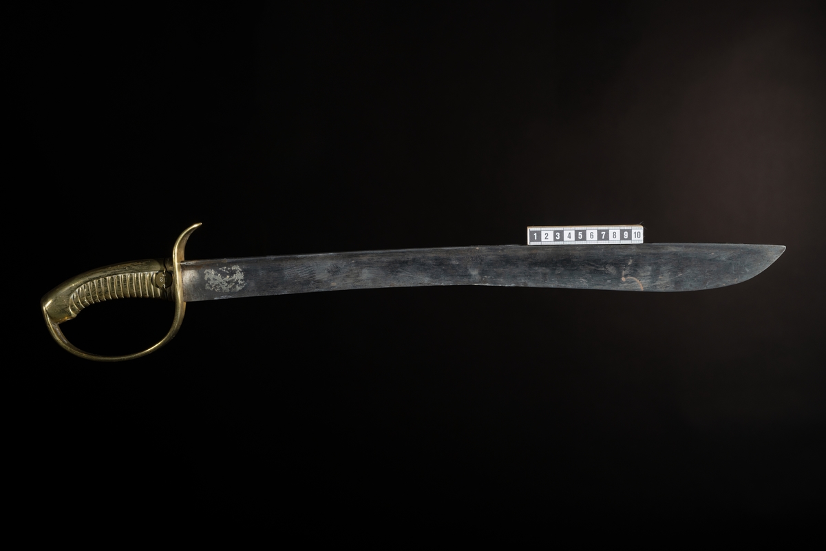 Huggare m/1846 för skeppsgossekåren med eneggad klinga av stål, Hafströms konstruktion. Fäste helt i mässing med räfflad kavel och parerstång som övergår i handbygel. Märkt : "1:C 86" instansat på parerstången, samt "82" instansat på en liten rund mässingsbricka, fästad med mässingstråd runt kaveln.