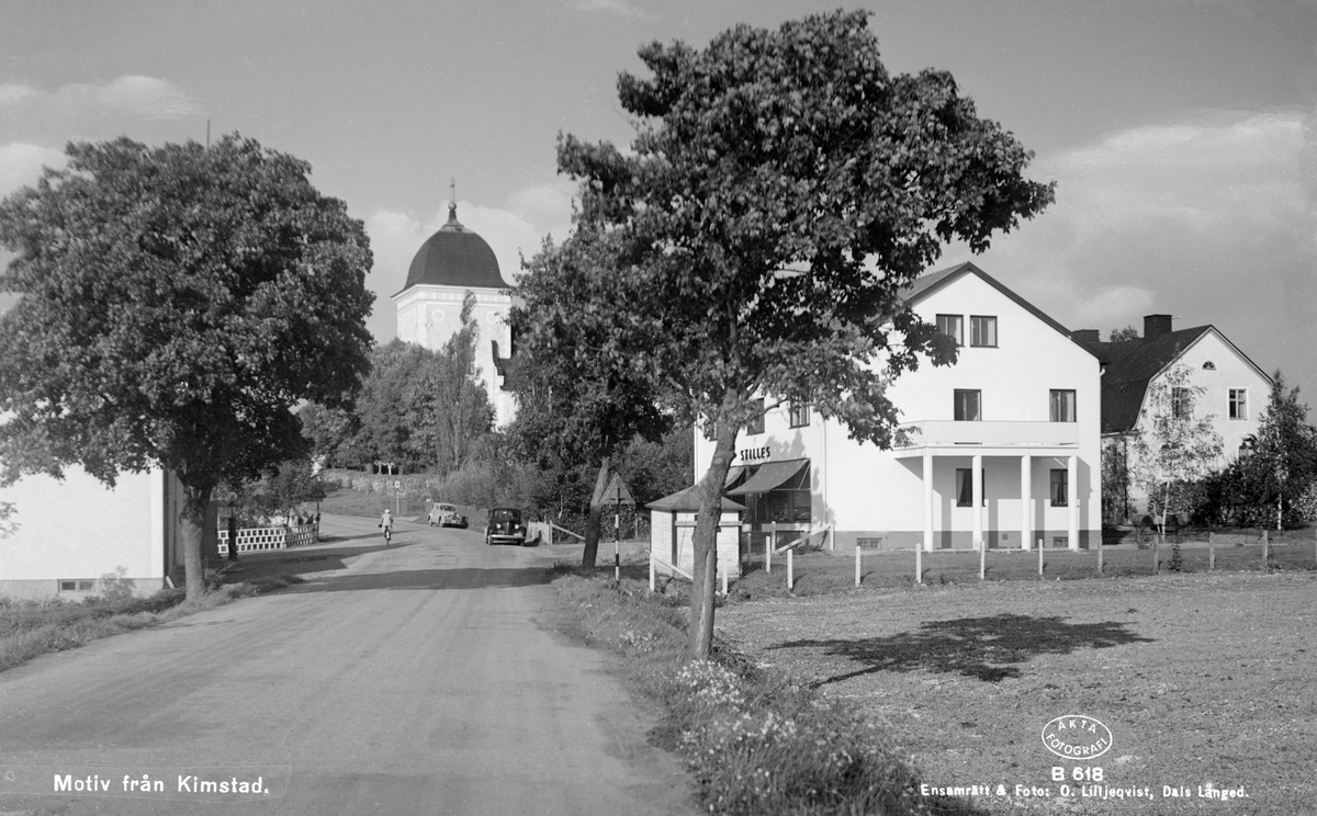 Motiv från Kimstad i Norrköpings kommun. Närmast i bild till höger ses köpman Sven Stilles butik. I bakgrunden siktas tornet till socknens ståtliga barockkyrka.