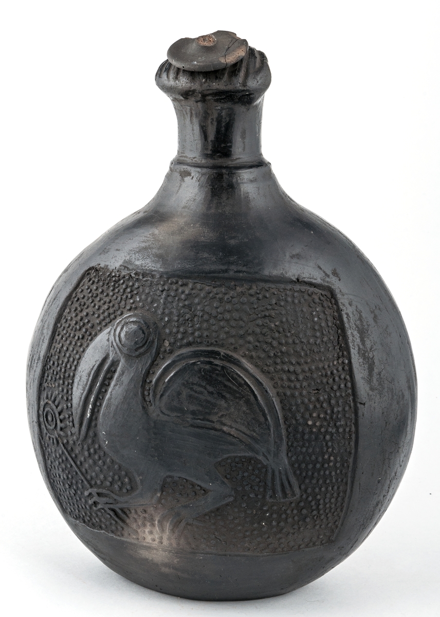 Gravkärl, inca, så kallat svartgods, med fågelhuvud, örn och pelikan.