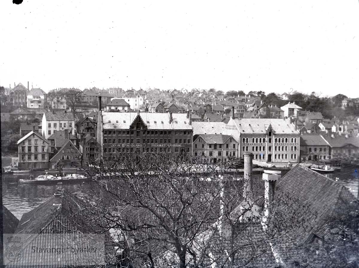 Hermetikkfabrikker langs Strandkaien..Gamle Stavanger mot Eiganes i bakgrunnen...John Braadland og Stavanger Preserving.Den gamle tollboden helt til høyre.