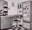 Fartygradiostation levererad av Standard Radio & Telefon AB år 1964. Längst till höger huvudsändare typ ST 1200 för mellanvåg, kusttelefoni och kortvåg. 1.2 kilowatt effekt.