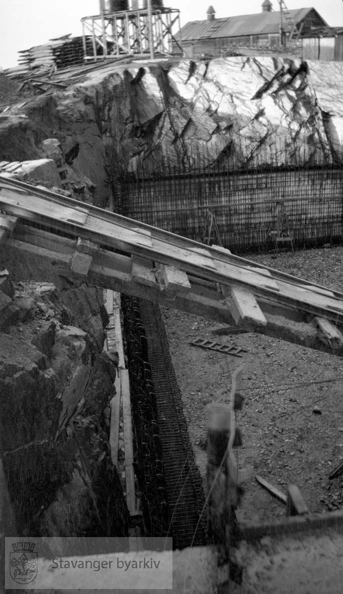 Skinnebro til frakting av byggemateriale...Vann fra Store Stokkavatn ble pumpet opp til bassenget på Tjensvollhøyden 89 m o.h.Stokkavatnanlegget startet opp i 1930 og fra da stilnet pumpene i Egenes brannstasjon. Stokkavatnet var byens vannreservoar fram til 1959.