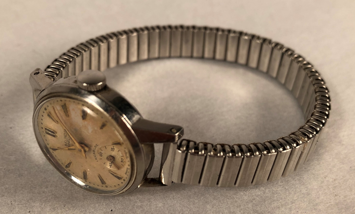 Klokke av stål med lenke med sekundviser (runding). Trekkes.