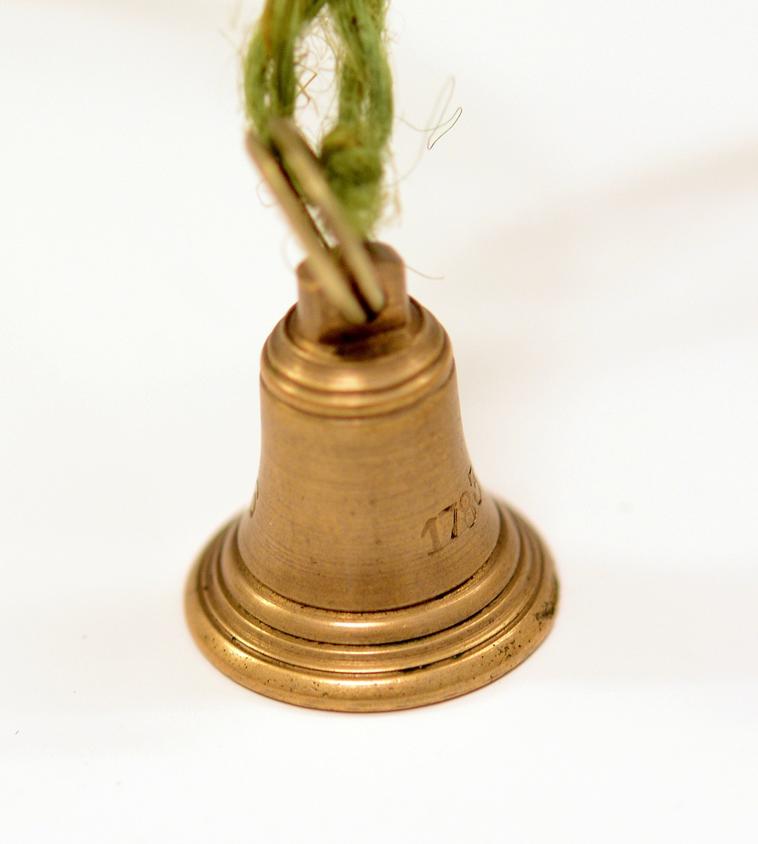 Signet av bronse, med initialene H.I. i dekorativ inngravering og ring rundt, støpt av Skiens gamle kirkeklokker, i klokkeform med feste på toppen og ring i. Medfølgende notat fra giveren til museet.