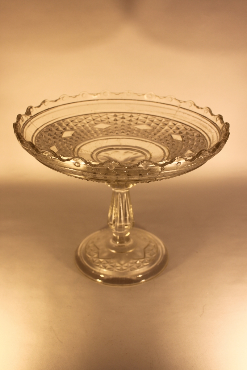 Kakfat på fot i pressat glas.