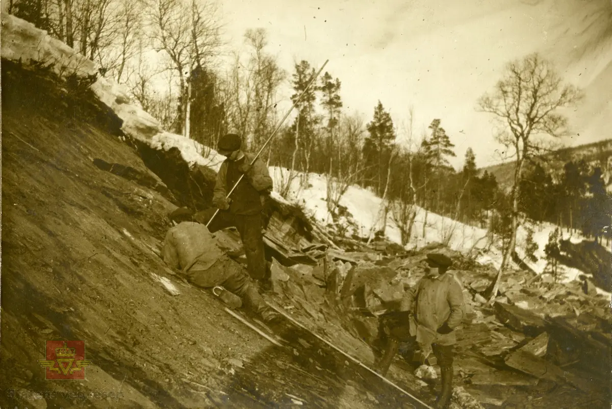 På bildet: Amtsingeniören  288/14 Bratsberg.  No2A.  "ECHO" Sprængninger i Kviknechausseen 13-2-1914.
9,2 meter dypt borehull - stænder-
Bergart: seig skifrig lerskifer
Ladning: 10 kg "ECHO".

Trolig er dette bildet fra Kvikne i Hedmark og vegen mellom Tynset og Ulsberg, dagens Rv 3. I følge Skougaard 1914 side 42 og 43 var anlegget påbegynt i 1905 og var enda ikke ferdig. Terrenget kan ligne Nord-Østerdalen. 

Det som forvirrer er at Kvikne ikke ligger i Bratsberg amt.
Trolig er dette "reklame" eller testing av sprengstoffer Echo som er sendt ut til Amtsingeniøren(e)?