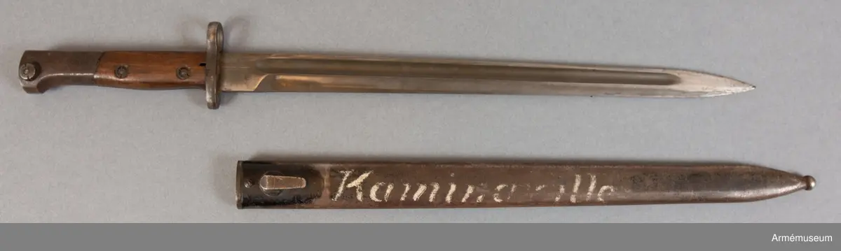 Banjonetten är en belgisk FN (Fabrique Nationale) m/1924 export. Den var applicerbar på bland annat Fabrique Nationale m/1924 gevär och Gewehr 98. Bajonetten härrör troligen från ett katangesiskt vapen och är märkt ”Kaminaville” som i det här fallet syftar på anfallet mot basen i Kaminaville på nyårsafton 1962. Det katangesiska gendarmeriet skulle avväpnas och tryckas tillbaka av både svenska och ghanesiska trupper. I det stora hela var det här en del av Operation Grandslam 28 december 1962 till och med 15 januari 1963. I och med operationen kunde det katangesiska upproret stoppas och FN återtog kontrollen över området. Motståndarsidan, det katangesiska gendarmeriet, stöddes av belgiska legosoldater och hade delvis också belgiska vapen och amerikanska pansarbilar till sitt förfogande.