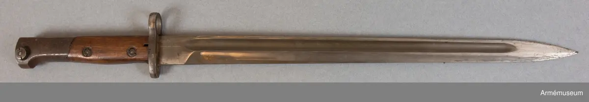 Banjonetten är en belgisk FN (Fabrique Nationale) m/1924 export. Den var applicerbar på bland annat Fabrique Nationale m/1924 gevär och Gewehr 98. Bajonetten härrör troligen från ett katangesiskt vapen och är märkt ”Kaminaville” som i det här fallet syftar på anfallet mot basen i Kaminaville på nyårsafton 1962. Det katangesiska gendarmeriet skulle avväpnas och tryckas tillbaka av både svenska och ghanesiska trupper. I det stora hela var det här en del av Operation Grandslam 28 december 1962 till och med 15 januari 1963. I och med operationen kunde det katangesiska upproret stoppas och FN återtog kontrollen över området. Motståndarsidan, det katangesiska gendarmeriet, stöddes av belgiska legosoldater och hade delvis också belgiska vapen och amerikanska pansarbilar till sitt förfogande.