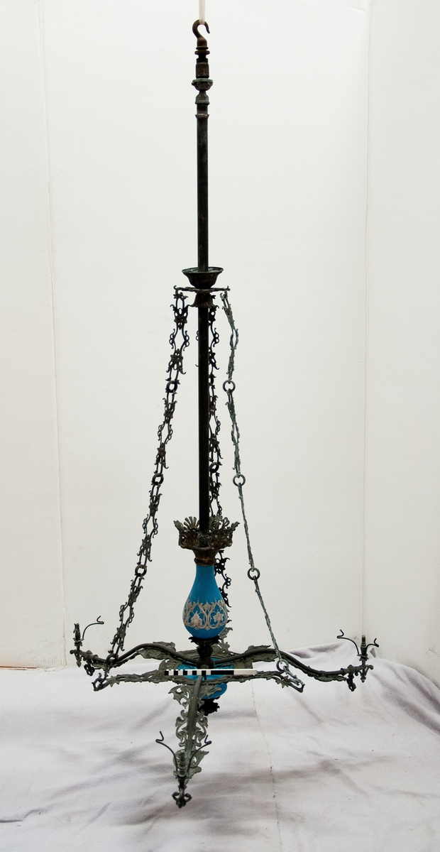 Trearmad takarmatur i metall, med ljusblått porslin.
Påhängd bricka med nr 17, etikett med text: "taklampa 3 armad delvis av blått porslin snittbrännare 1860-tal". Tre kupor saknas, blått glas inne i armaturen.