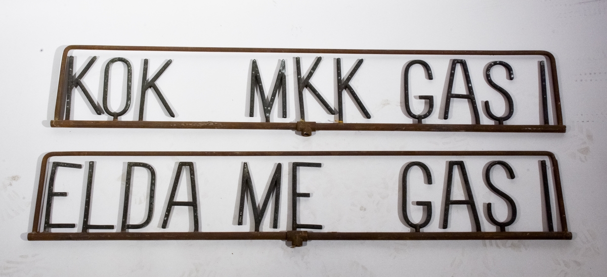 Ljusramper, två st., av metall med texten "Elda me_ gas !" på den ena och "Kok _mkk gas !" på den andra.