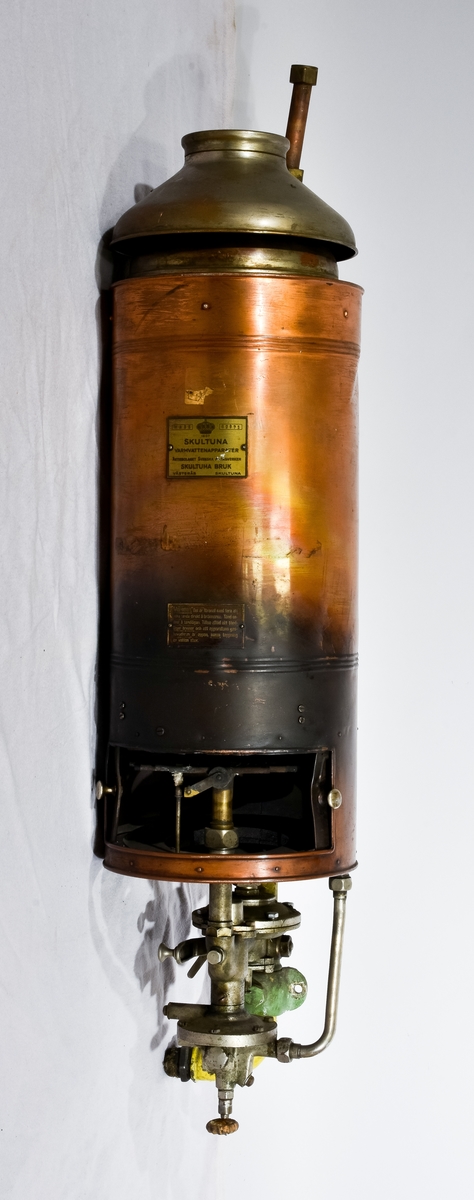 Bronsfärgad varmvattenberedare med texten "Skultuna Varmvattenapparater aktiebolaget Svenska metallverken Skultuna bruk Västerås Skultuna" , WA 35, 52971 på sig.