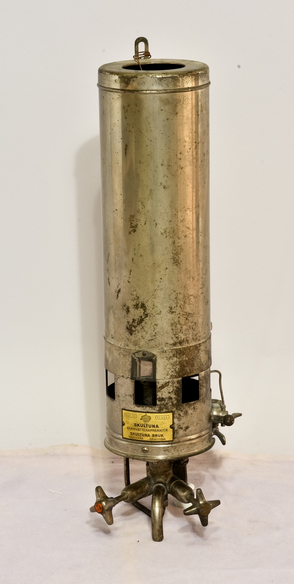 Varmvattenberedare i metall med texten "Har texten " 1607 Skultuna, Varmvattenapparater, Aktiebolaget Svenska Metallverken, Skultuna, Västerås Sverige" på sig, samt två nr: MT 12, 77075.