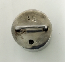 Sylinder i metall med håndtak.