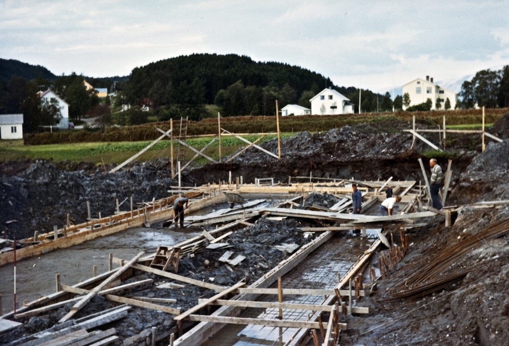 Leirfjord, Leland. Bygging av det nye sykehjemmet. Bak til høyre sees Leland skole (nå kulturhuset). Hesjer sees mellom byggeplassen og skolebygningen.