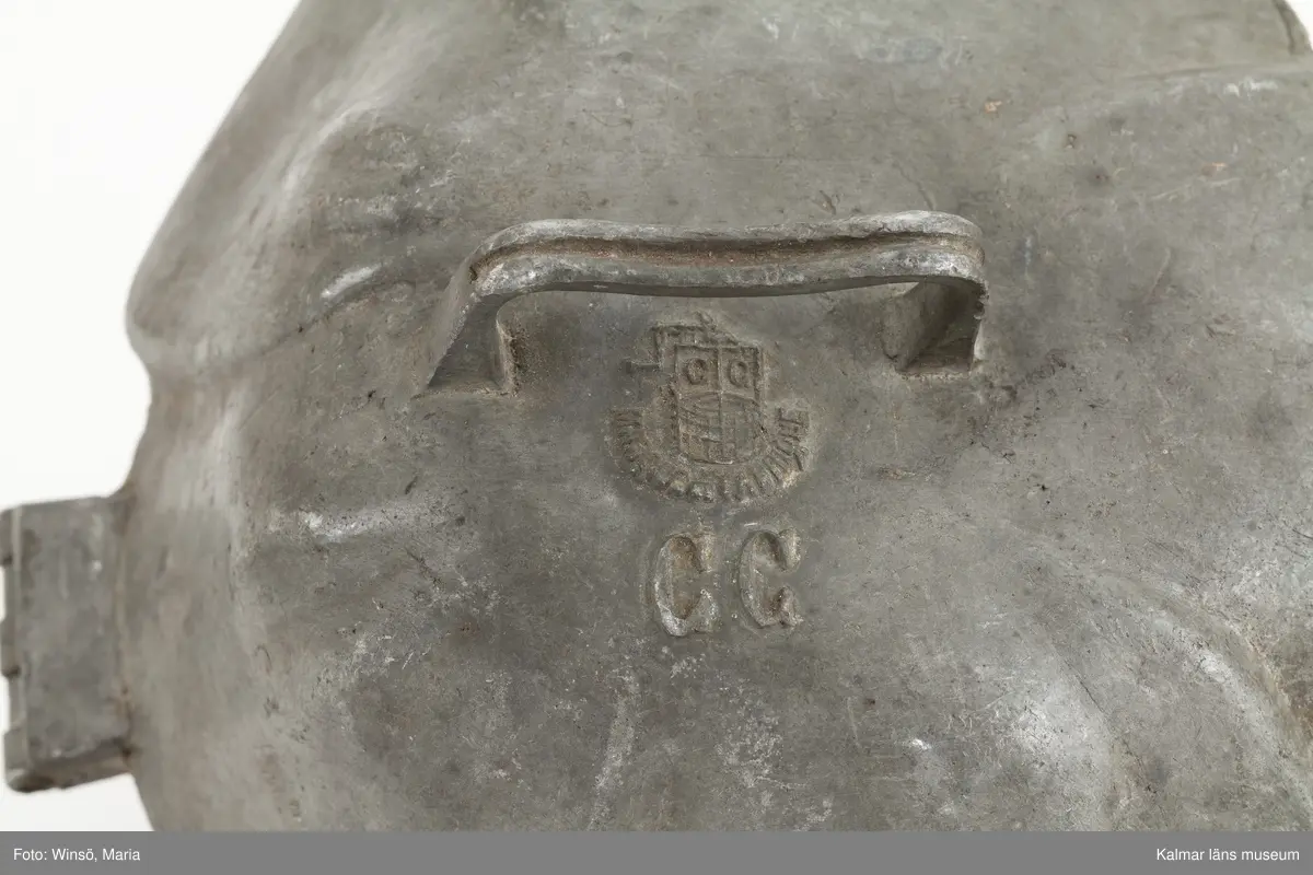 KLM 28437:49, Glassform, av tenn. Form, utformad som en ros, krönt med en liggande kerub, handtag och tre gångjärn. Stämplar: Marque de Fabrique C.C. ; Breveté S.G.D.G. Formen tillverkad av firman Cadot et Cie, tillverkare av konfektyrformar i Paris, under 1800-talet.