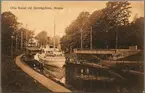 Ångfartyget Motalaström på tur längs Göta Kanal passerar järnvägsbron på linjen mellan Motala och Fornåsa.