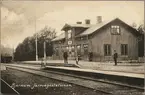 Station med personal och barn på perrong.