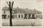 Vägsida av Eskilstuna C station med personal utanför stationshus.