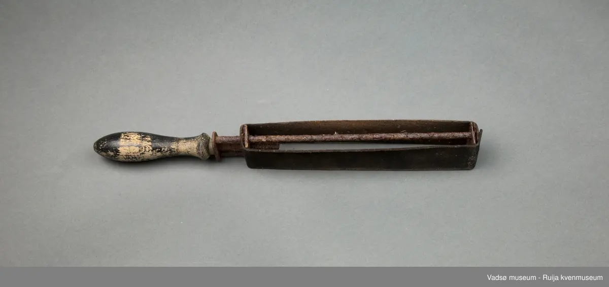 Håndholdt knivsliper. Slipebåndet av lær er spent rundt en enkel ramme av jernspiler. Håndtak i tre. Til finsliping av kniver.