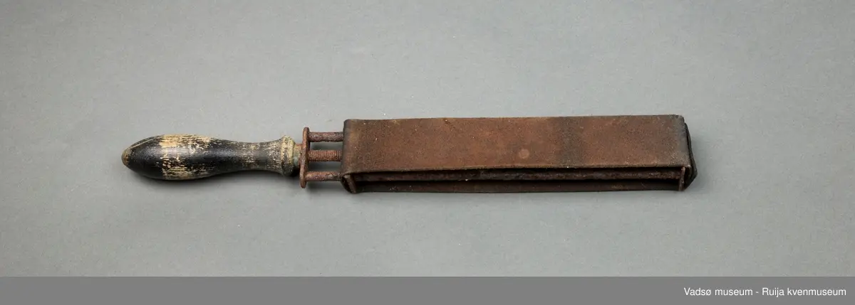 Håndholdt knivsliper. Slipebåndet av lær er spent rundt en enkel ramme av jernspiler. Håndtak i tre. Til finsliping av kniver.