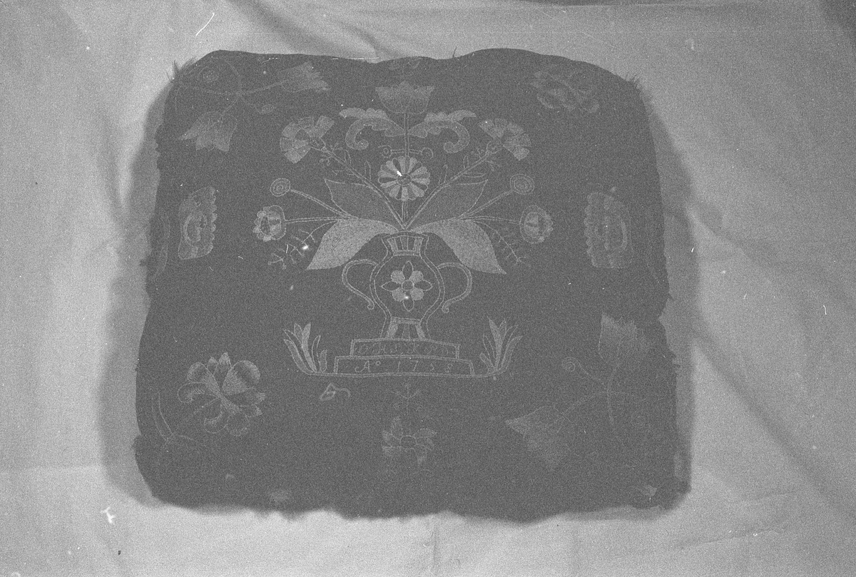 Pute av ull brodert med blomstermotiv og med underside av skinn