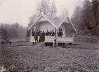 Gruppbild med soldater och civila framför en byggnad.