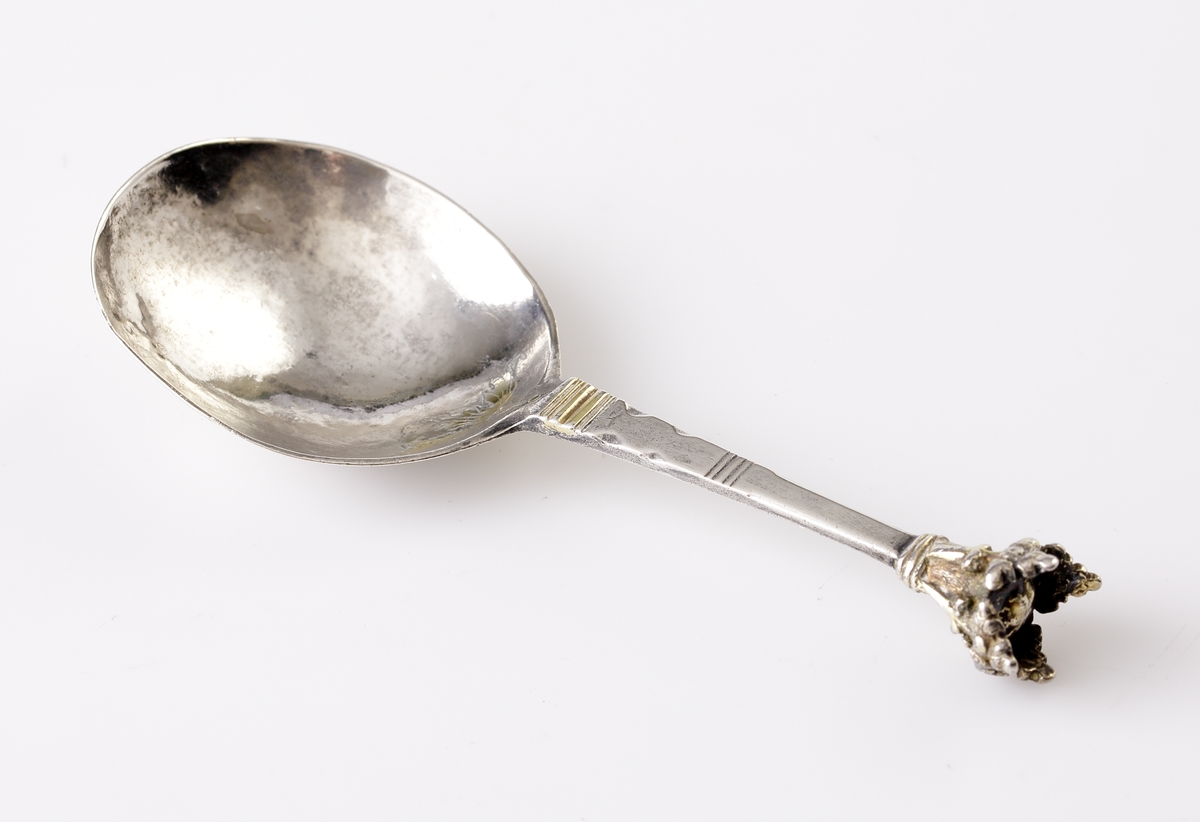 Brännvinssked av silver.
Graverad blomma (delvis förgylld) i skedbladet. Försedd med kronknopp. Stämplar + åldermansranka på baksidan av skaftet (mycket otydliga). Kan ev. vara: Johan Wibom (Wiberg?) (1680-1710), Norrköping.
F = 1698 ?.