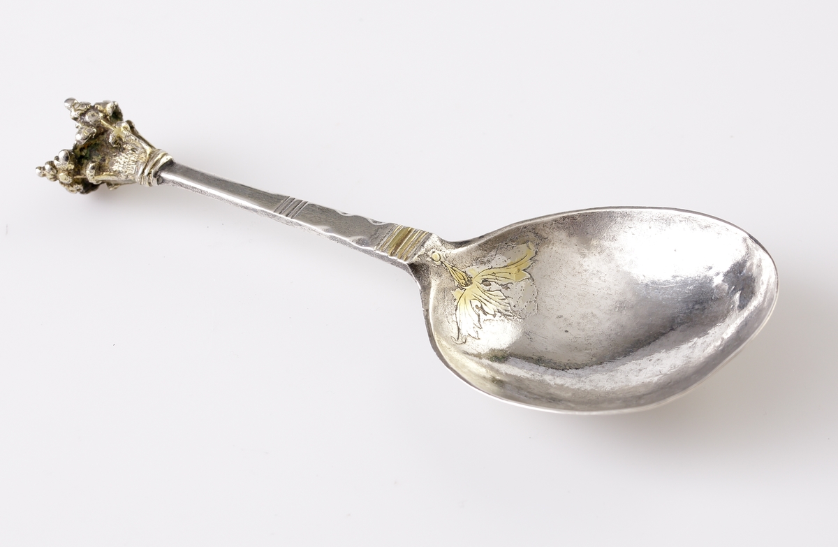 Brännvinssked av silver.
Graverad blomma (delvis förgylld) i skedbladet. Försedd med kronknopp. Stämplar + åldermansranka på baksidan av skaftet (mycket otydliga). Kan ev. vara: Johan Wibom (Wiberg?) (1680-1710), Norrköping.
F = 1698 ?.