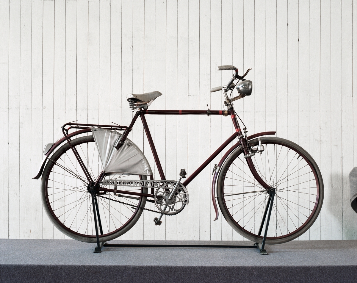 Kedjedriven herrcykel med navväxel, framhjulsbroms samt belysning Bosch med dynamo. Ram av stålrör med skärmar och fälgar av plåt, kedjeskydd av aluminium. Plastklädd sadel och ett kjolskydd av galon.
Namnskylt på ramen märkt: Bergsingeniör Kurt Jeanson, Tennisvägen 65, Rotebro, Tel: 7140651. Pakethållaren är trasig.
Lås av märke City Balloon, medföljer en nyckel.
Tillbehör: Liten metallbygel för att fixera hjulet mot ramen.